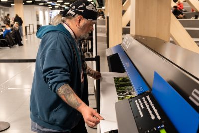 Henkilö tulostaa suurkuvatulostimella.